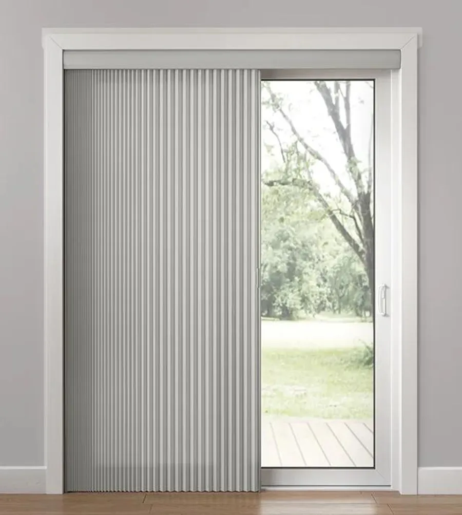 Vertical honeycomb shades with light-blocked fabric on glass door